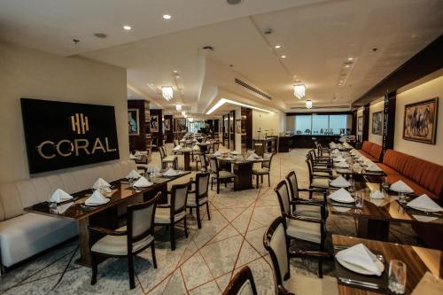 un comedor con mesas y sillas y un restaurante en Coral Tower Hotel by Hansa, en Amán