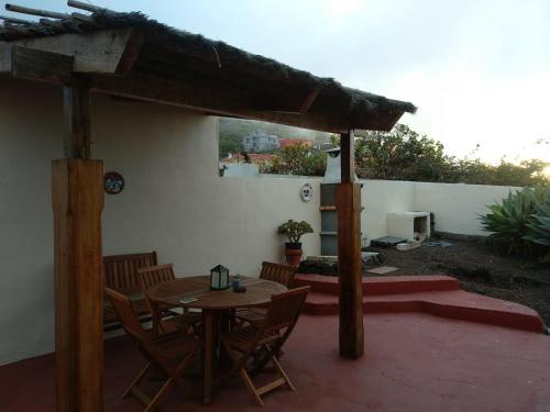 un patio con tavolo e sedie in legno di casa rural Aguarijo a Mocanal