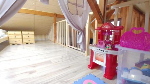 a childs bedroom with a crib and a toy house at Sielanówek - Orzechowa Chatka z sauną wanną termalną jacuzzi in Żywiec