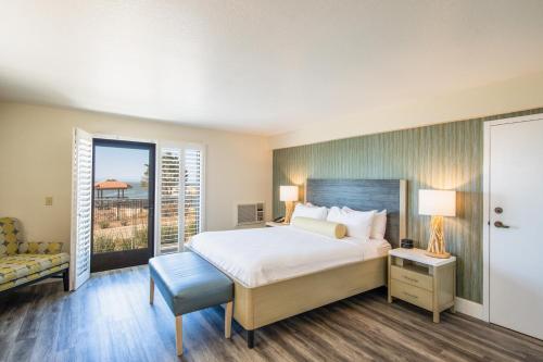 a bedroom with a bed and a balcony at Inn at the Cove in Pismo Beach