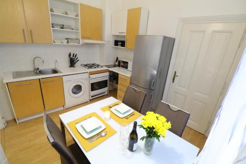a kitchen with a table and a kitchen with a refrigerator at Apartment HVIEZDKO in Bratislava