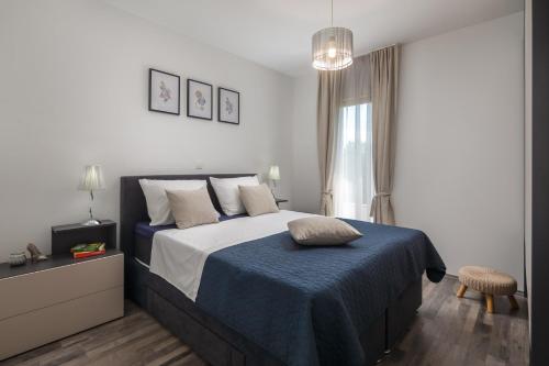 a bedroom with a bed with a blue blanket and a window at Villa Dali - luxury holiday house in relaxing area in Sičane