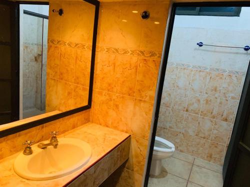 a bathroom with a sink and a toilet at Hotel Real Jojutla in Jojutla de Juárez