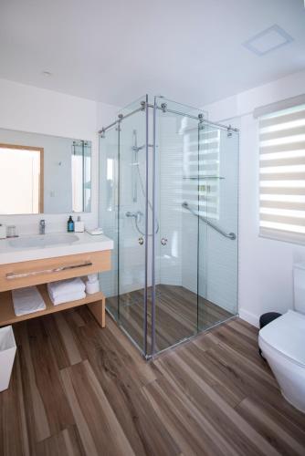 a bathroom with a shower and a toilet and a sink at Finch Bay Galapagos Hotel in Puerto Ayora