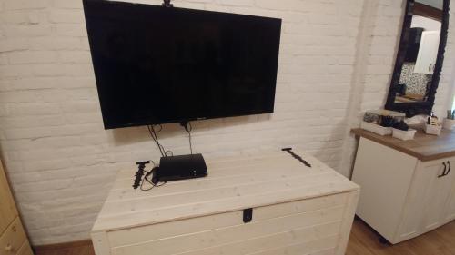 a flat screen tv on top of a dresser at Sielanówek - Orzechowa Chatka z sauną wanną termalną jacuzzi in Żywiec