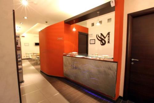 a restaurant with an orange wall and a counter at Albergo Miramonti in Potenza