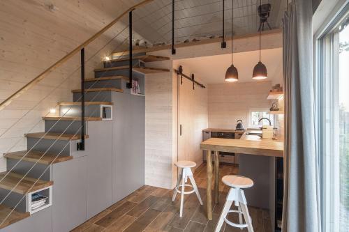 a staircase in a tiny kitchen with a counter and stools at Tiny Vacation in Písek