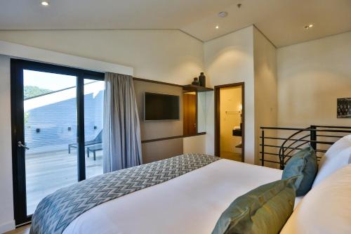a bedroom with a bed and a sliding glass door at Quality Hotel Blumenau in Blumenau