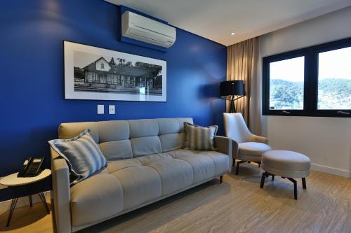 a blue living room with a couch and a chair at Quality Hotel Blumenau in Blumenau