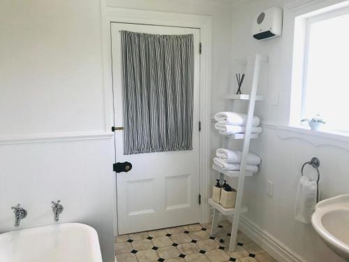 a bathroom with a white tub and a sink at Bryce Cottage in Cambridge