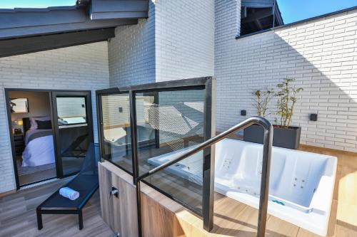 a hot tub on a balcony with a bedroom at Quality Hotel Blumenau in Blumenau