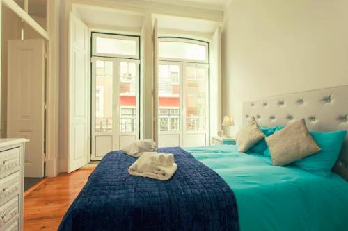 een slaapkamer met een blauw bed en handdoeken bij Traditional & Charm house in Graça in Lissabon