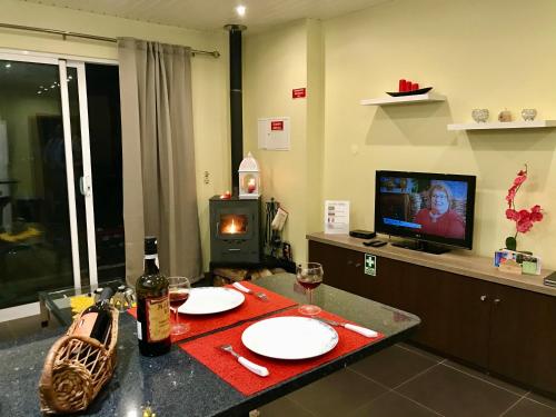 a living room with a table and a fireplace at Casa da Relva com Piscina Aquecida Interna in Arco da Calheta