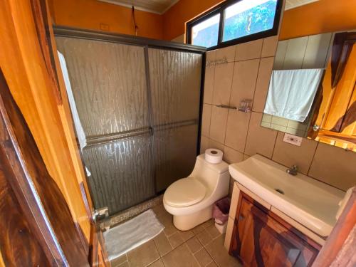 a bathroom with a toilet and a sink at Valle Encantado in San Isidro de El General