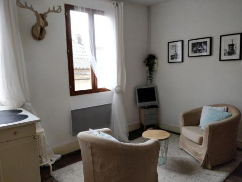 uma sala de estar com duas cadeiras e uma janela em Studio Les Armuriers em Condom
