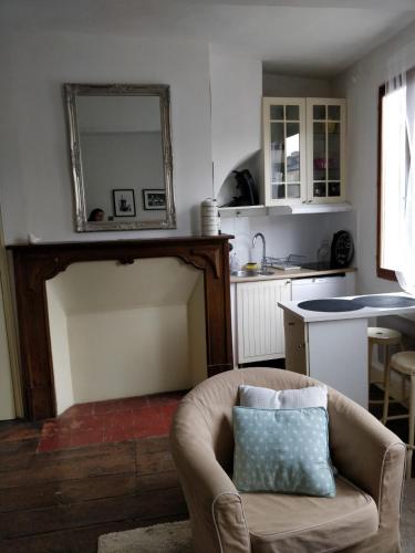 un salon avec une chaise et un miroir dans l'établissement Studio Les Armuriers, 2ème étage sans asc, à Condom