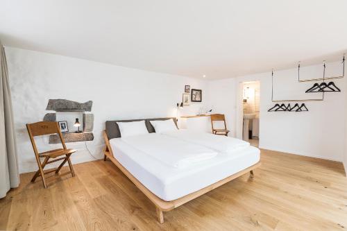 a bedroom with a large white bed and a chair at Montmartre in Zürich