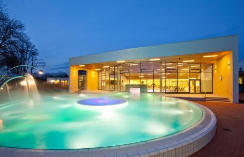 a large pool in front of a building with a fountain at Vitalhotel der Parktherme in Bad Radkersburg