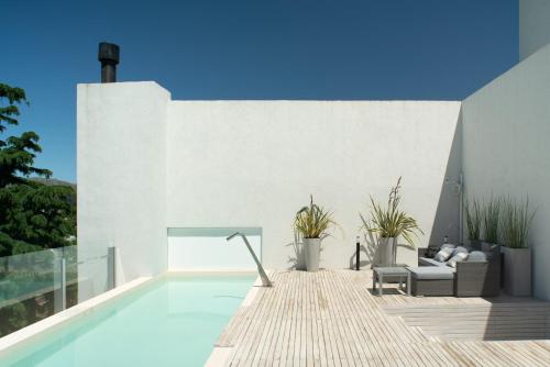 a swimming pool in a house with a white wall at T Design Hotel Boutique in Tandil