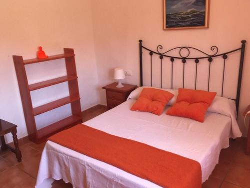 a bedroom with a large bed with orange pillows at Casa en Bolonia muy cerca de la playa in Bolonia