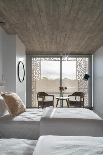 a bedroom with two beds and a table with chairs at T Design Hotel Boutique in Tandil