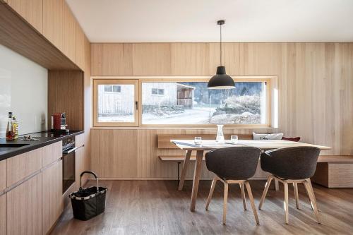 uma cozinha com mesa e cadeiras e uma janela em Tempel 74 Apartments em Mellau