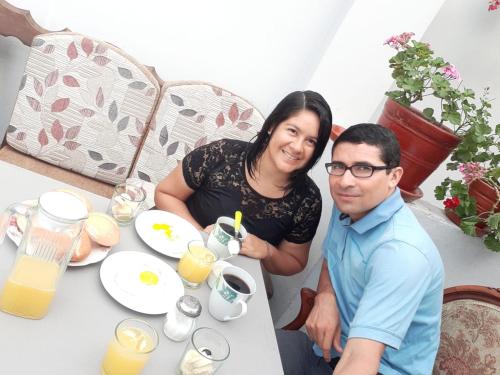 un homme et une femme assis à une table avec de la nourriture dans l'établissement Dormitorio Independiente, à Lima