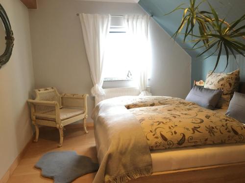 1 dormitorio con cama, ventana y silla en Ferienwohnung zur Himmelsscheibe new Art, en Ziegelroda