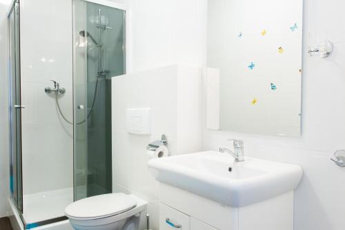 a bathroom with a sink and a toilet and a shower at Marina in Jarosławiec
