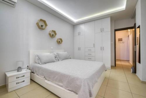 1 dormitorio blanco con 1 cama grande y armarios blancos en Athens Near Acropolis, en Atenas
