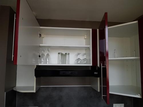 Una cocina con gabinetes blancos y jarrones de vidrio. en Appart 4-6 pers Berck-Plage Hyper-centre, en Berck-sur-Mer