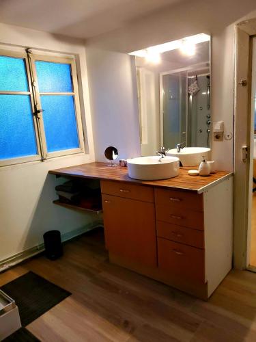 une salle de bain avec deux lavabos et un grand miroir dans l'établissement charmant appartement alsacien, à Rodern