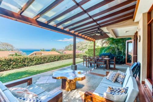 a patio with couches and a table with a view at Bahia Pez Vela Villa in Ocotal