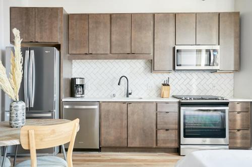 una cocina con electrodomésticos de acero inoxidable y armarios de madera en Sonder at REVEL, en Minneapolis