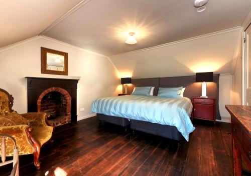 a bedroom with a large bed and a fireplace at Ventnor Guest House in South Bruny