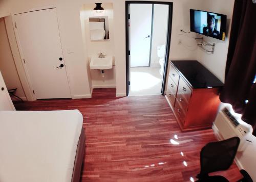 a room with a bed and a bathroom with a sink at Anchor Pointe Inn in Wilmington