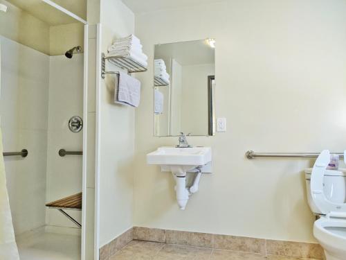 a bathroom with a sink and a toilet and a mirror at Anchor Pointe Inn in Wilmington