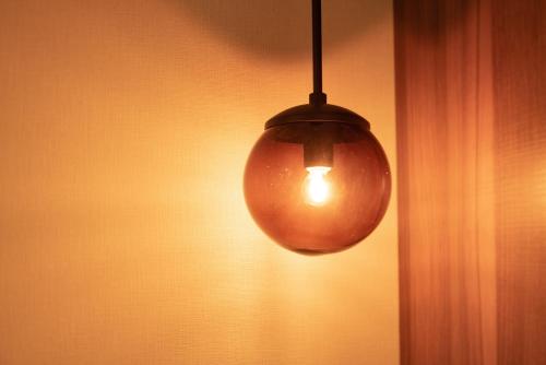a light bulb hanging from the side of a wall at HOTEL FORZA HAKATAEKI CHIKUSHIGUCHI Ⅱ in Fukuoka