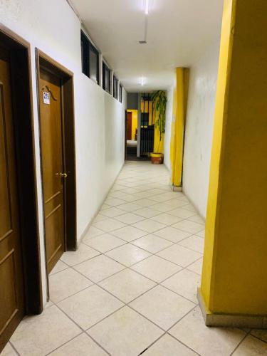 an empty hallway with a tile floor and doors at Hotel Real Jojutla in Jojutla de Juárez