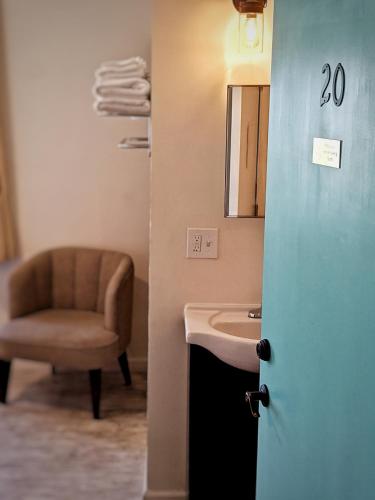 a bathroom with a sink and a chair at Anchor Pointe Inn in Wilmington