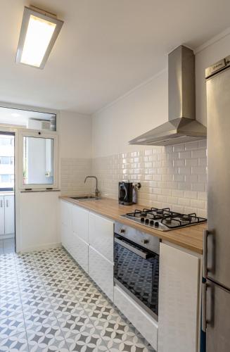 a white kitchen with a stove and a sink at Matosinhos Relax and Fun by PortoProperties4You in Matosinhos