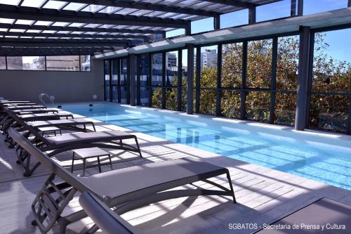 a large swimming pool with lounge chairs in a building at Hotel 15 de Mayo in Mar del Plata