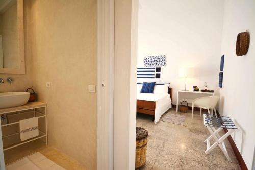 a bedroom with a bed and a bathroom with a sink at Fuoridalguscio Home in Leuca