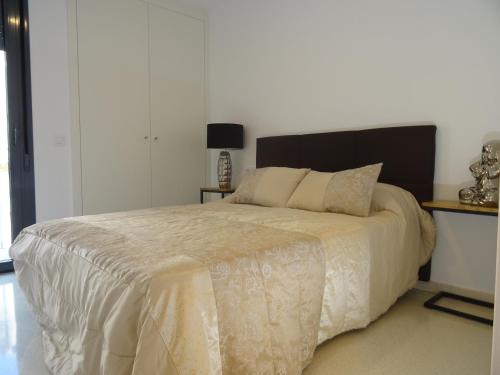 1 dormitorio con 1 cama grande y edredón blanco en Apartamento Plaza San benito 4, en Calatayud
