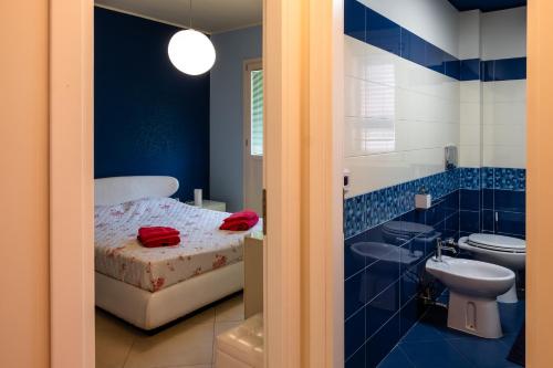 a bathroom with a bed and a sink and a toilet at casa di alessio a 200 metri dal mare in Acireale