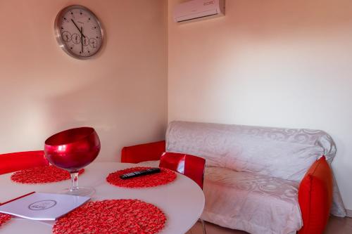 a table with a glass of wine and a couch at casa di alessio a 200 metri dal mare in Acireale