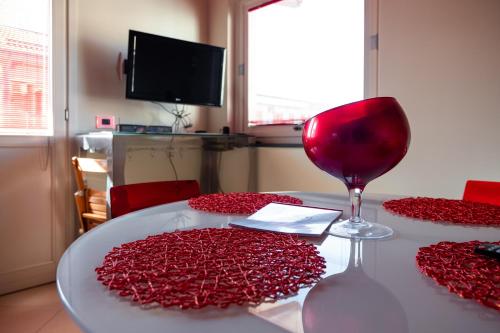 a table with a wine glass and red hearts on it at casa di alessio a 200 metri dal mare in Acireale
