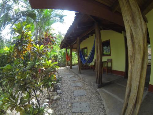 a porch of a house with a hammock on it at Indra Inn in Playa Grande