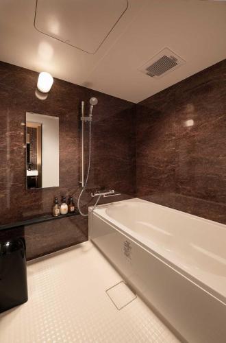 a large bathroom with a tub and a sink at Connect inn Shichijo-Kamogawa in Kyoto