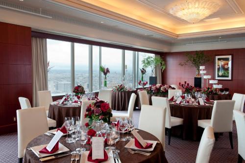 a banquet room with tables and chairs and a large window at ANA Crowne Plaza Toyama by IHG in Toyama